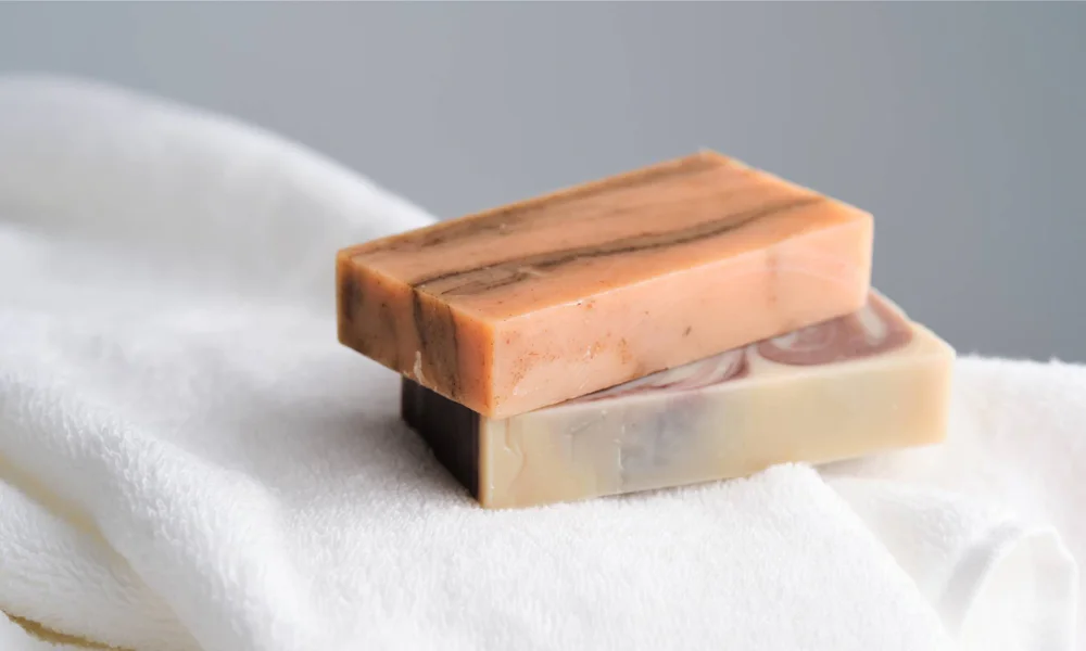Two fragrance-free soap bars resting on a soft, white towel, perfect for gently cleaning and caring for your skin.