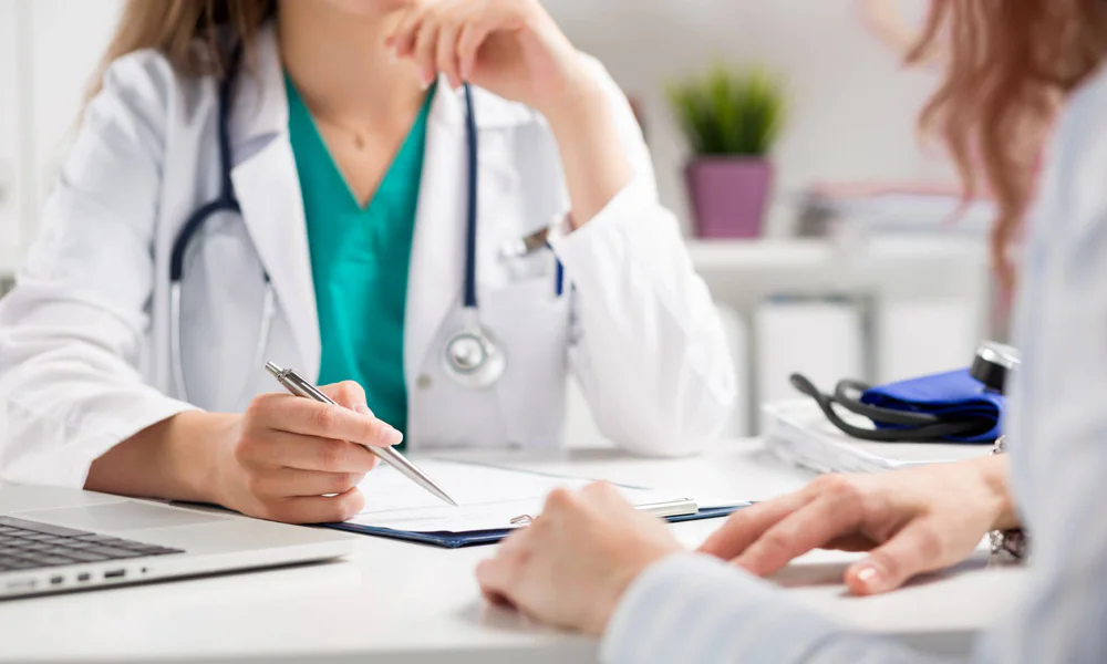 Doctor in a medical office consulting a patient, highlighting the importance of medical advice before getting a tattoo.