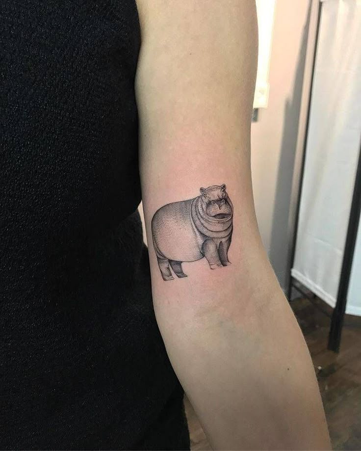 Hippopotamus tattoo on the left bicep.
