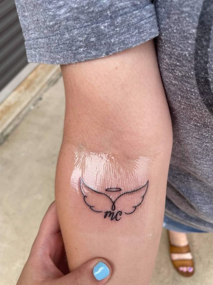 Angel wings, halo and initials tattoo