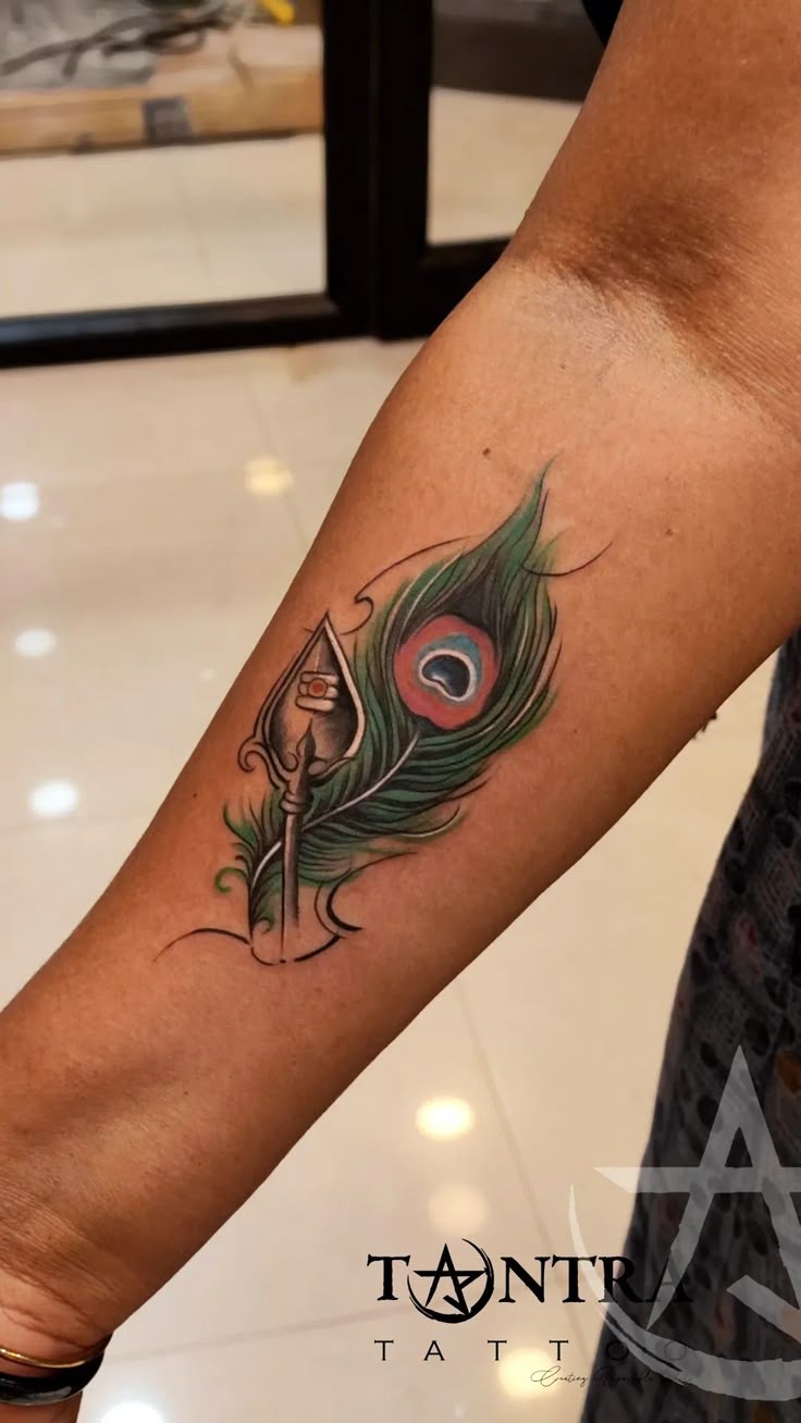 Murugar vel tattoo with peacock feather tattoo