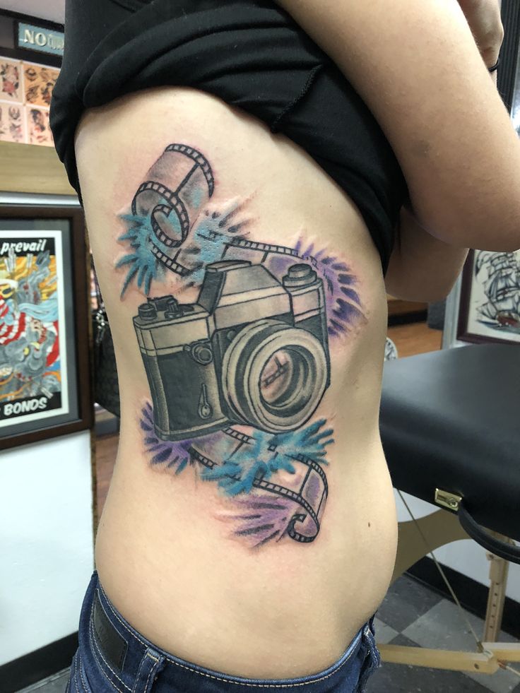 Water color camera tattoo I absolutely love photography. I got this done at  #nokingstattoo The artist did an absolutely amazing job. He took my idea of  a film strip with a camera