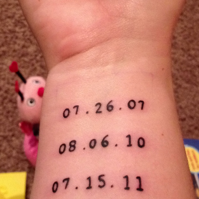 Wrist tattoo is children's birthdays.
