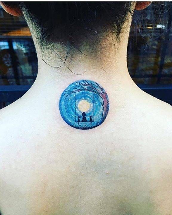 Small illustrative circle tattoo of a swing on the
