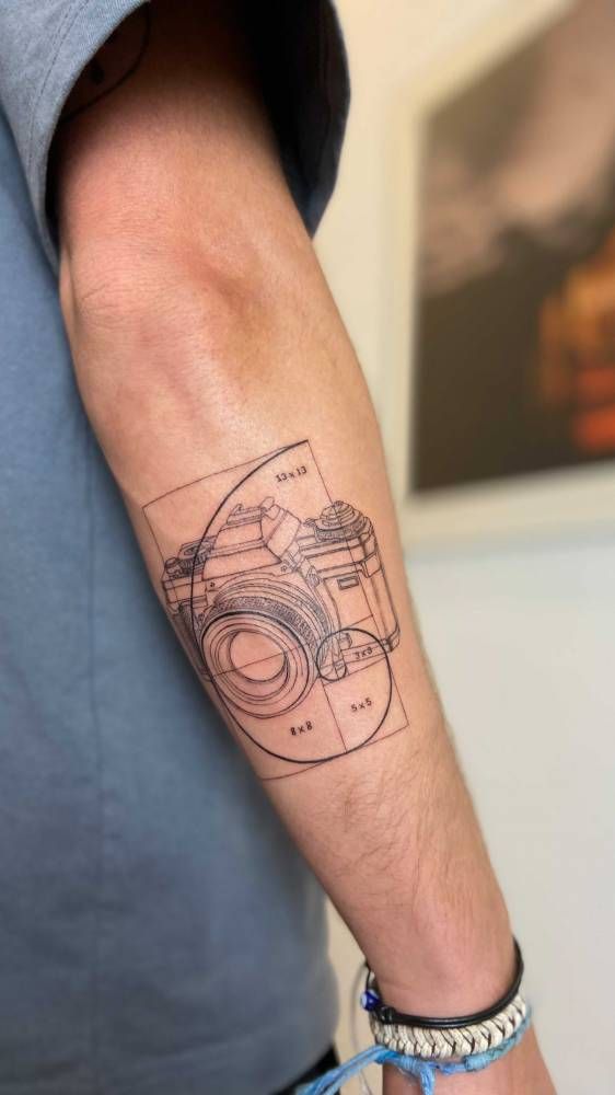 Golden spiral camera tatttoo done on the forearm.