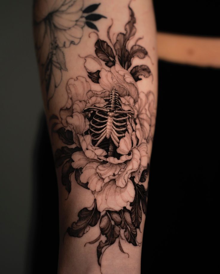 Here's a tattoo that captures the contrast of life and death. This piece,  done for my client Cylie during my guest spot in Vancouver at @lamaison. tattoo features a skeleton ribcage intertwined with
