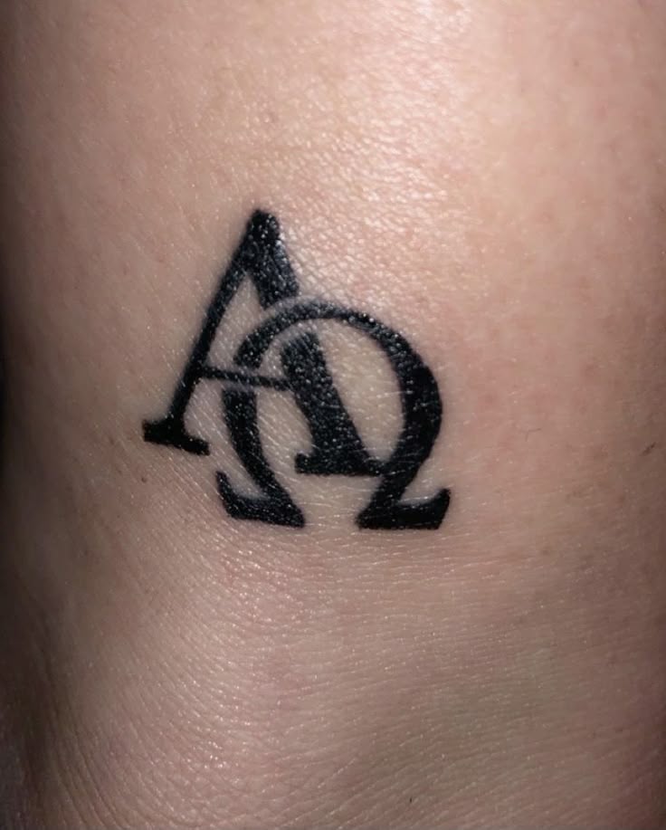 minimalist alpha + omega tattoo